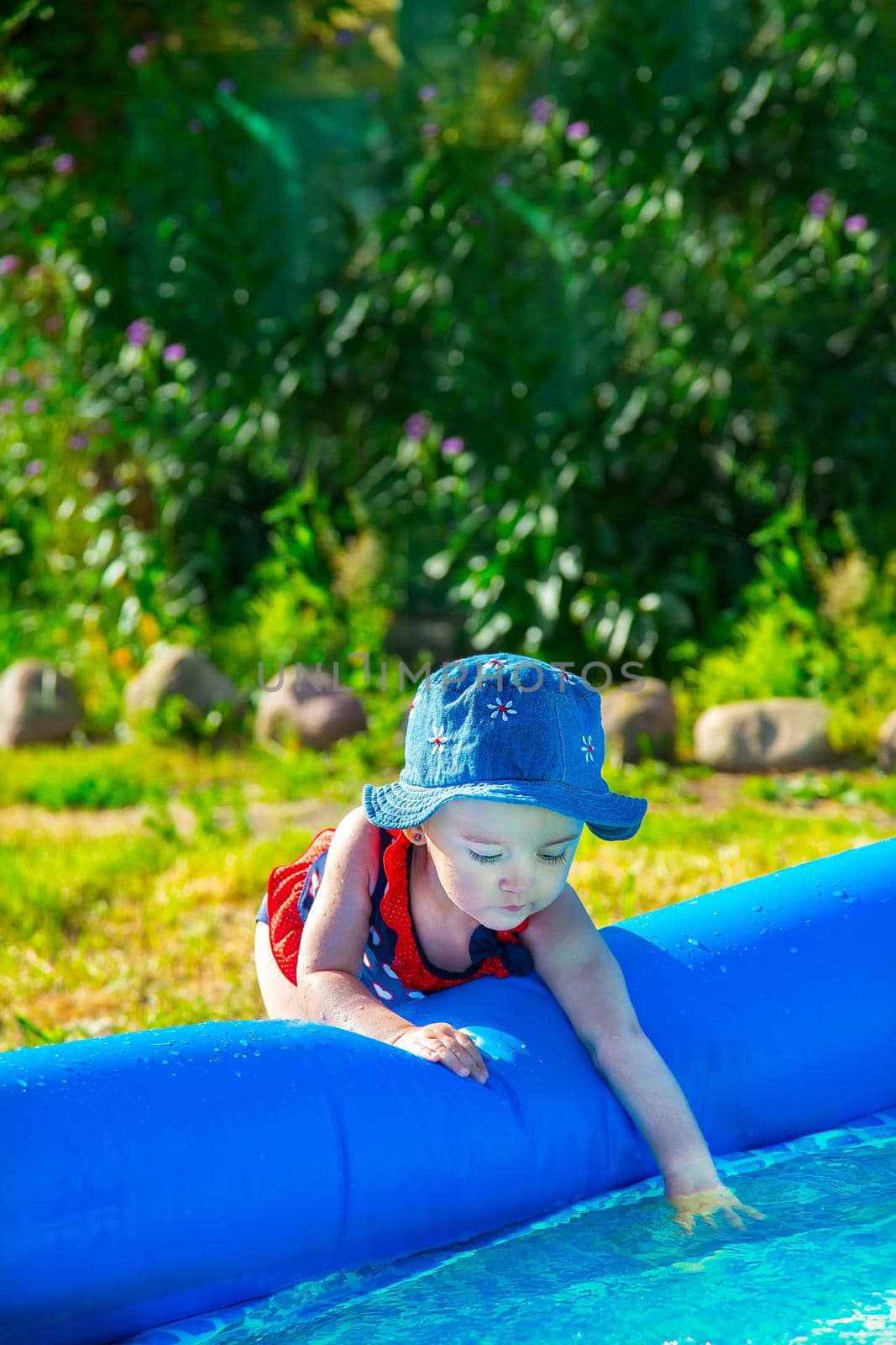 Little girl playing near the inflatable pool