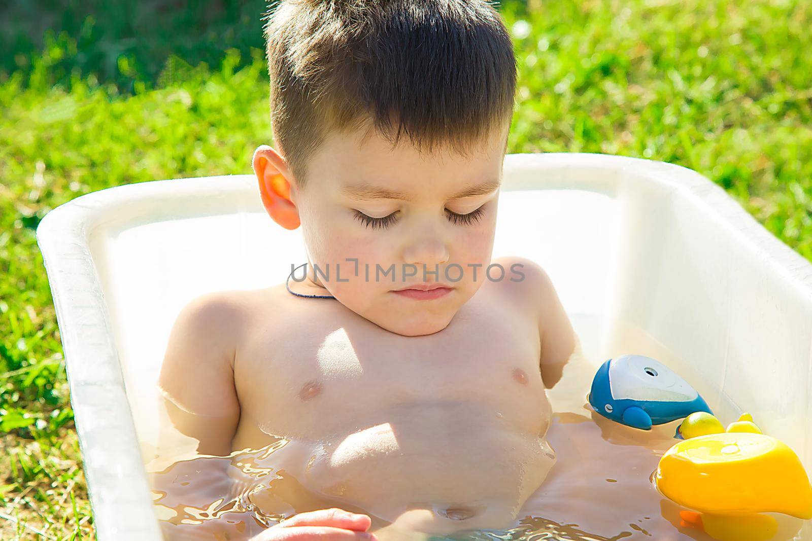 A boy of preschool age on a hot summer day fell asleep in the bath