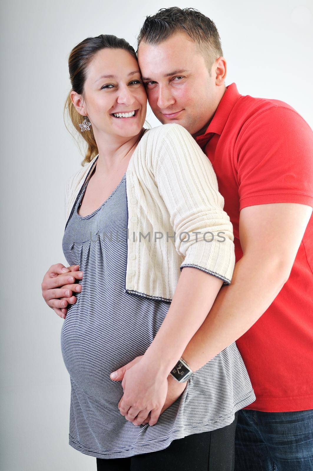 young family couple together in studio isolated on white. happy and waiting for baby