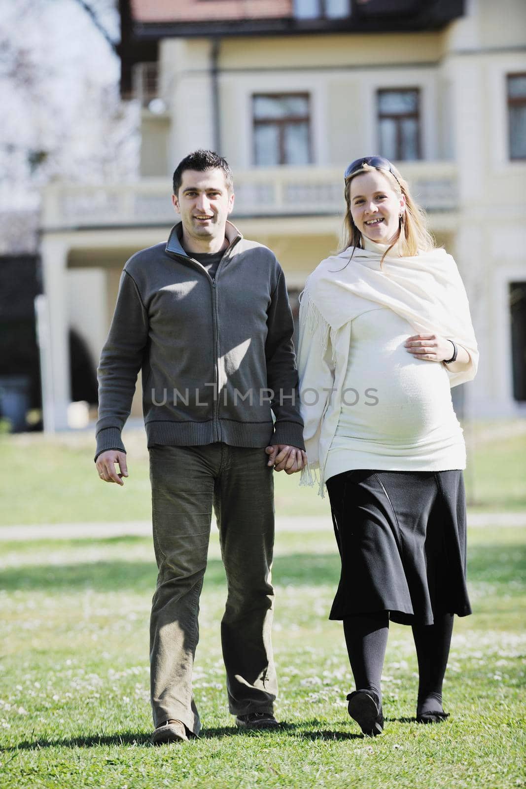 happy young married family couple outdoor in nature have fun and waiting baby and representing young family growth and pregnancy concept