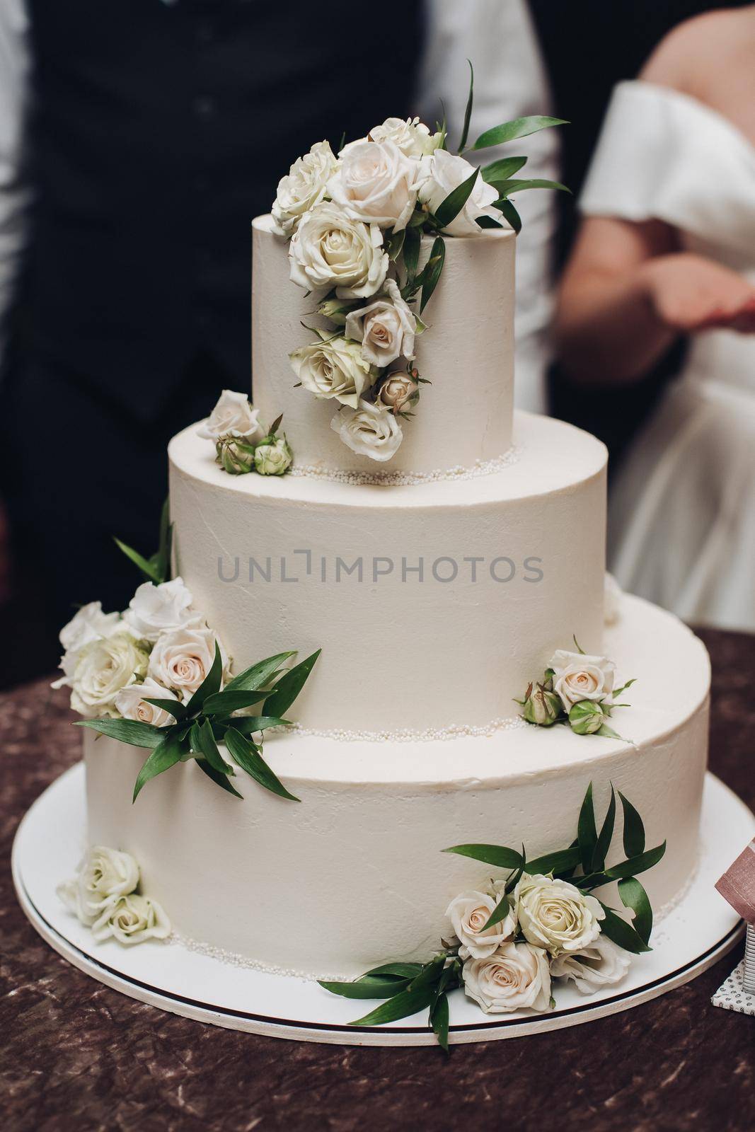 picture of a big white three grade cake with yummy flowers on it