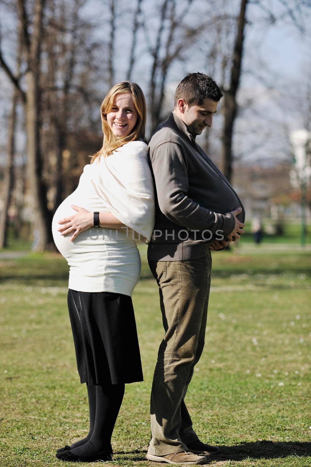 happy young married family couple outdoor in nature have fun and waiting baby and representing young family growth and pregnancy concept