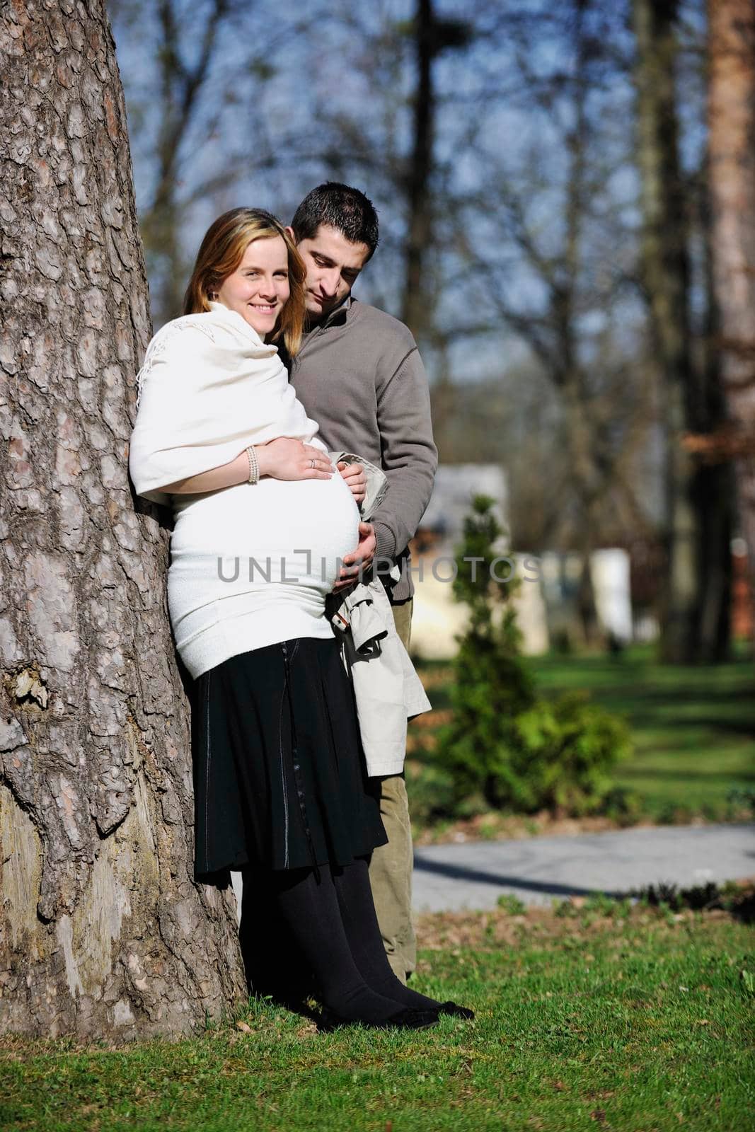 happy young married family couple outdoor in nature have fun and waiting baby and representing young family growth and pregnancy concept