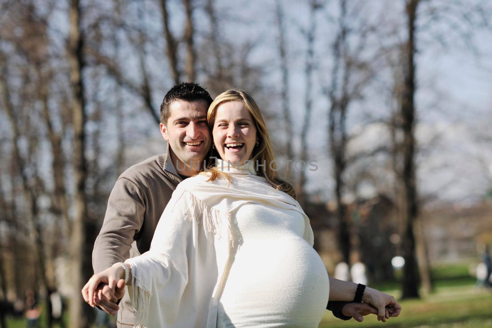 happy young married family couple outdoor in nature have fun and waiting baby and representing young family growth and pregnancy concept