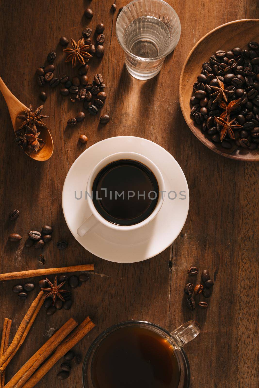 Black coffee in a cup on the background of coffee beans in a composition with accessories by makidotvn