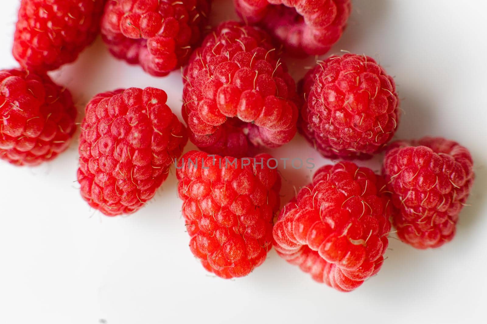 Picture of raspberries in triangle shape lies isolated on a white background. Cut out, close up. Background and picture for postcard.