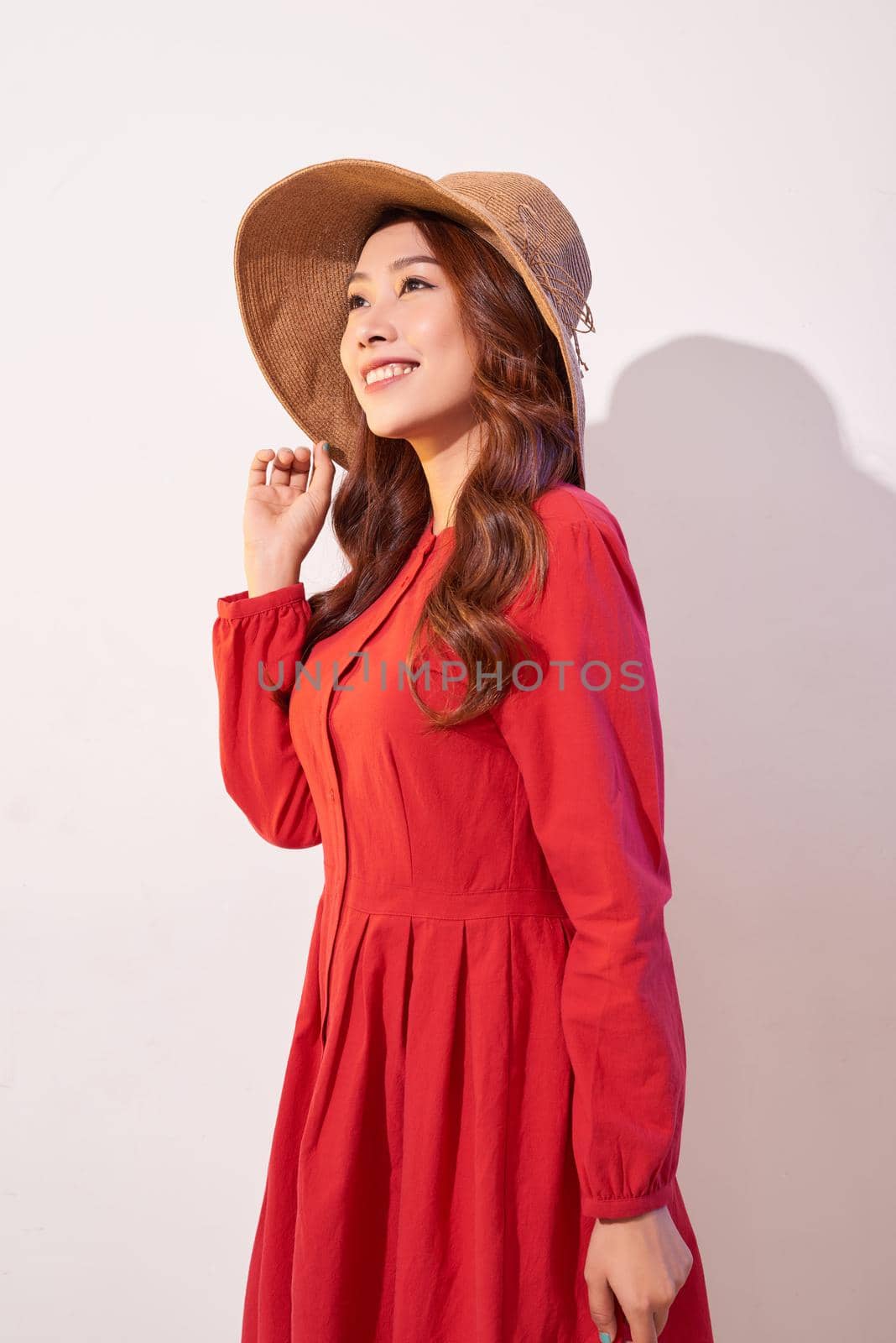 Beautiful young lady in straw hat over white background