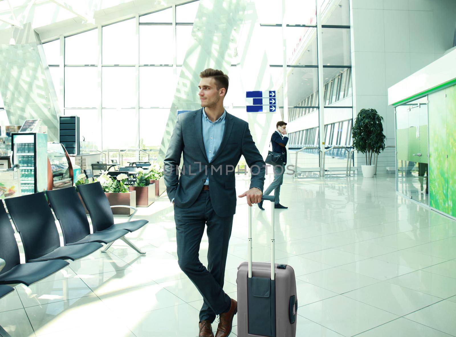 Business man with suitcase in hall of airport. by tsyhun