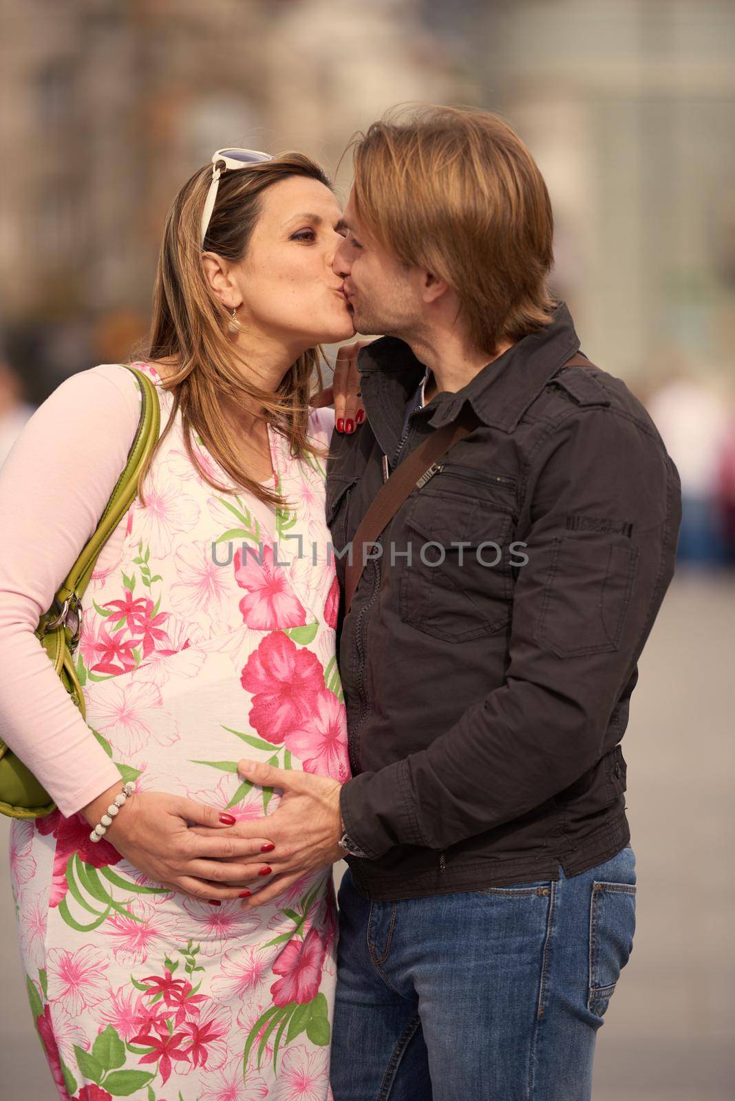 Happy and young pregnant couple have fun and relax outdoor