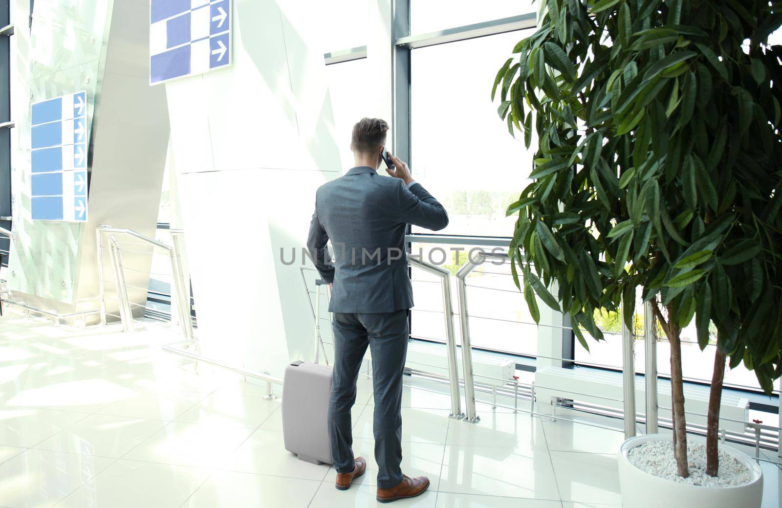 Businessman speaking on the phone at the airport.