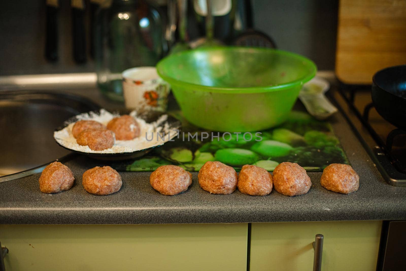 Cooking meatballs, ready mince lies by roasting on the kitchen table by StudioLucky