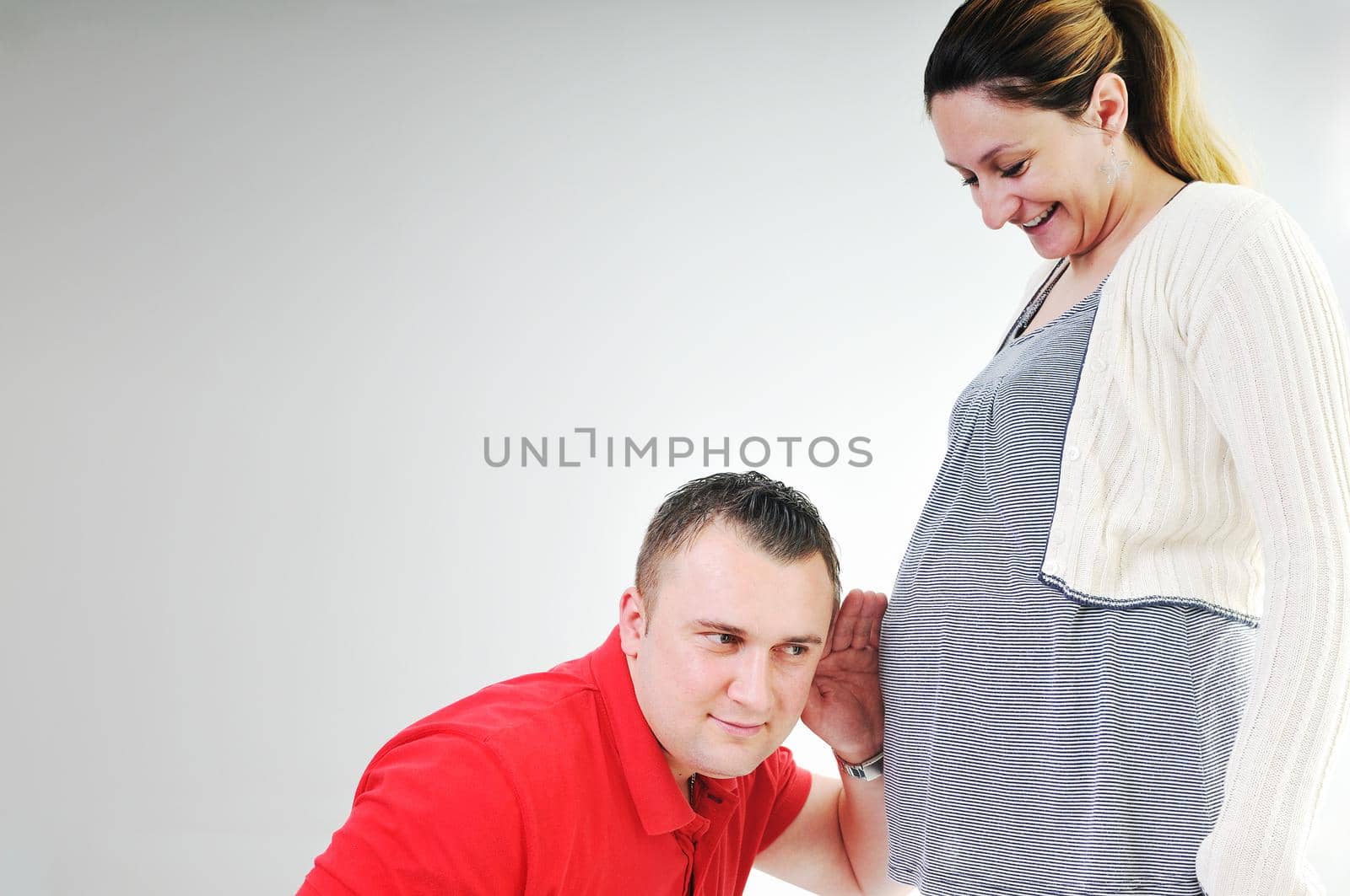 young family couple together in studio isolated on white. happy and waiting for baby