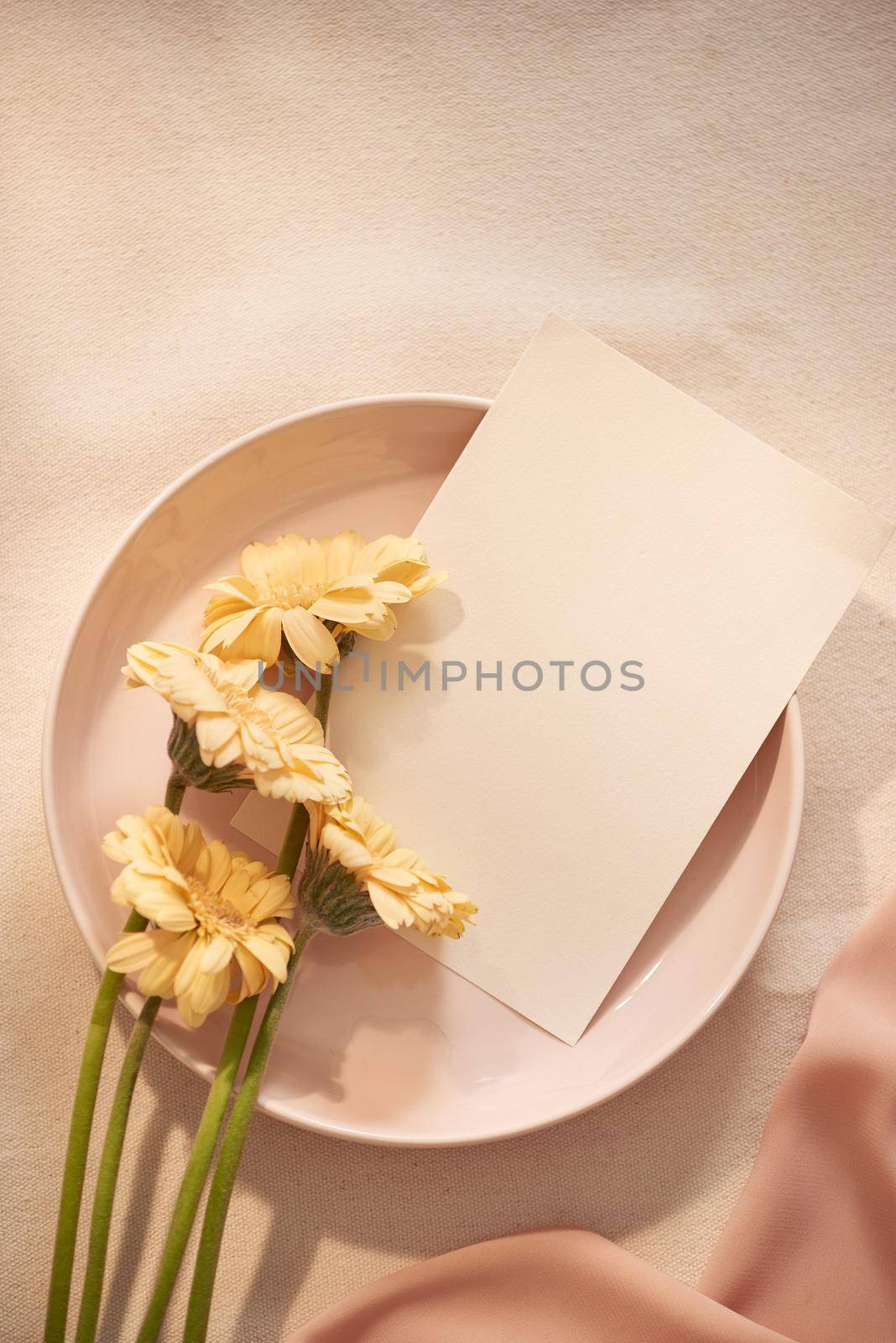 Flowers on plate with card and fabric on the light background by makidotvn