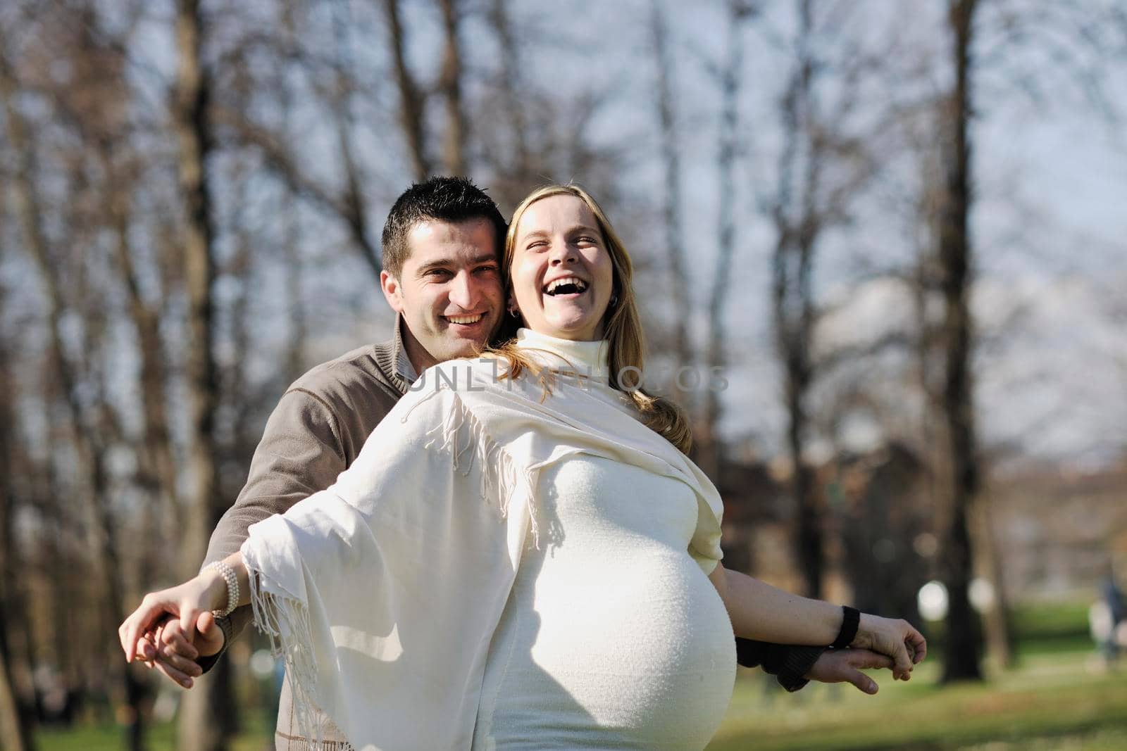 happy young married family couple outdoor in nature have fun and waiting baby and representing young family growth and pregnancy concept