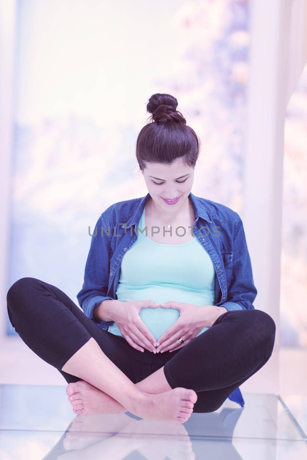 happy pregnant women enjoying pregnancy relaxing at home sitting on the floor
