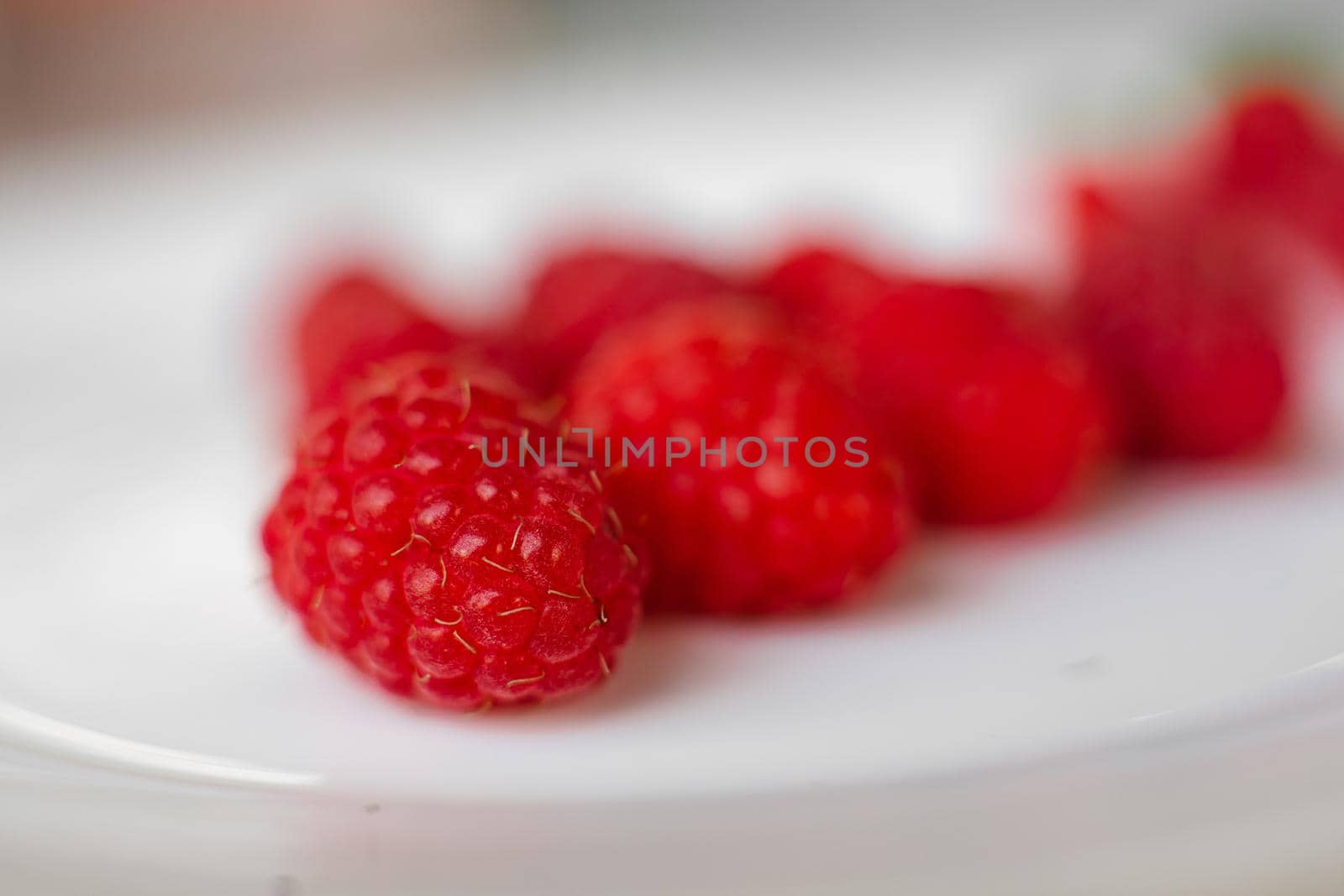 Collected raspberries on white background. Concept of love. Juicy raspberries dessert. by StudioLucky