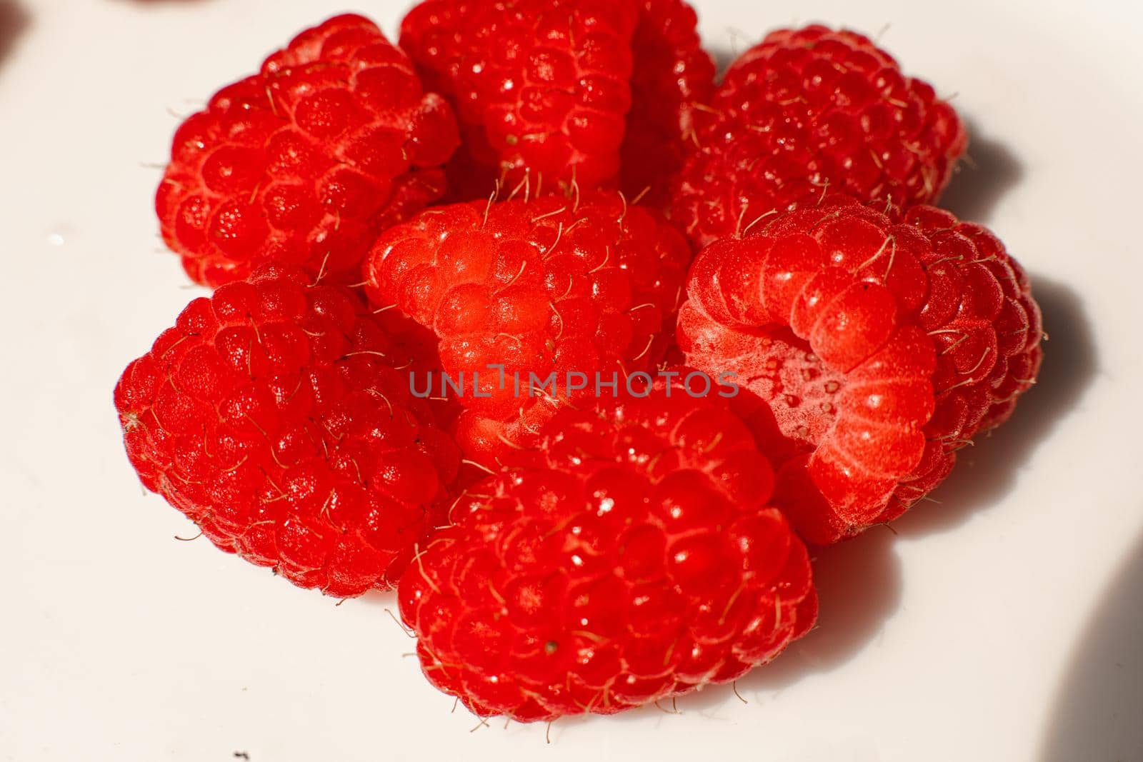 A picture of a few raspberries lies on a white background. Background and picture for postcard by StudioLucky