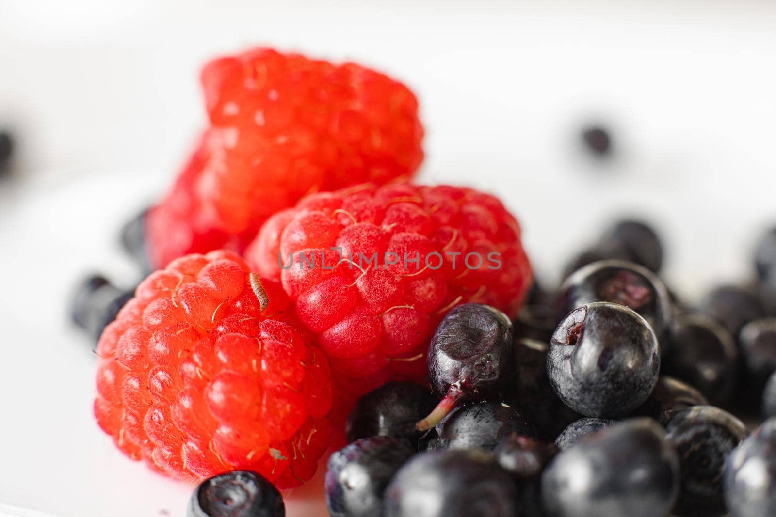 Two different kinds on berries on white plate by StudioLucky