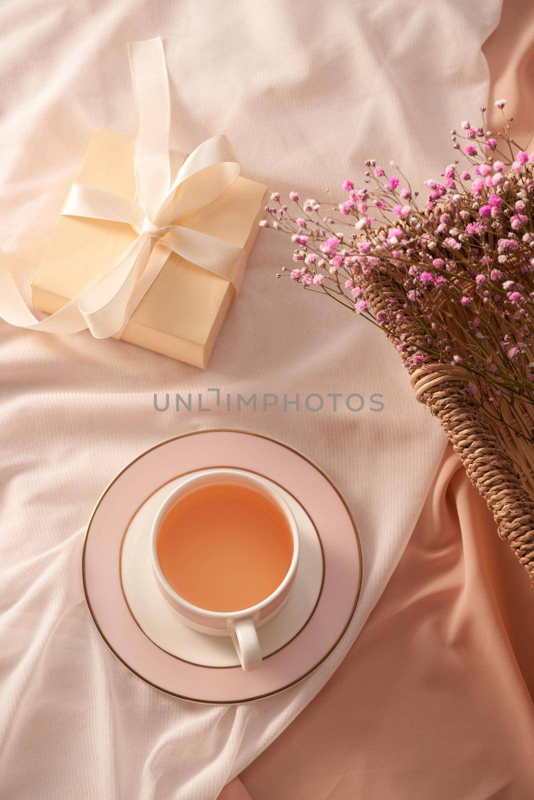 Cup of tea, gift box and flowers on light background by makidotvn