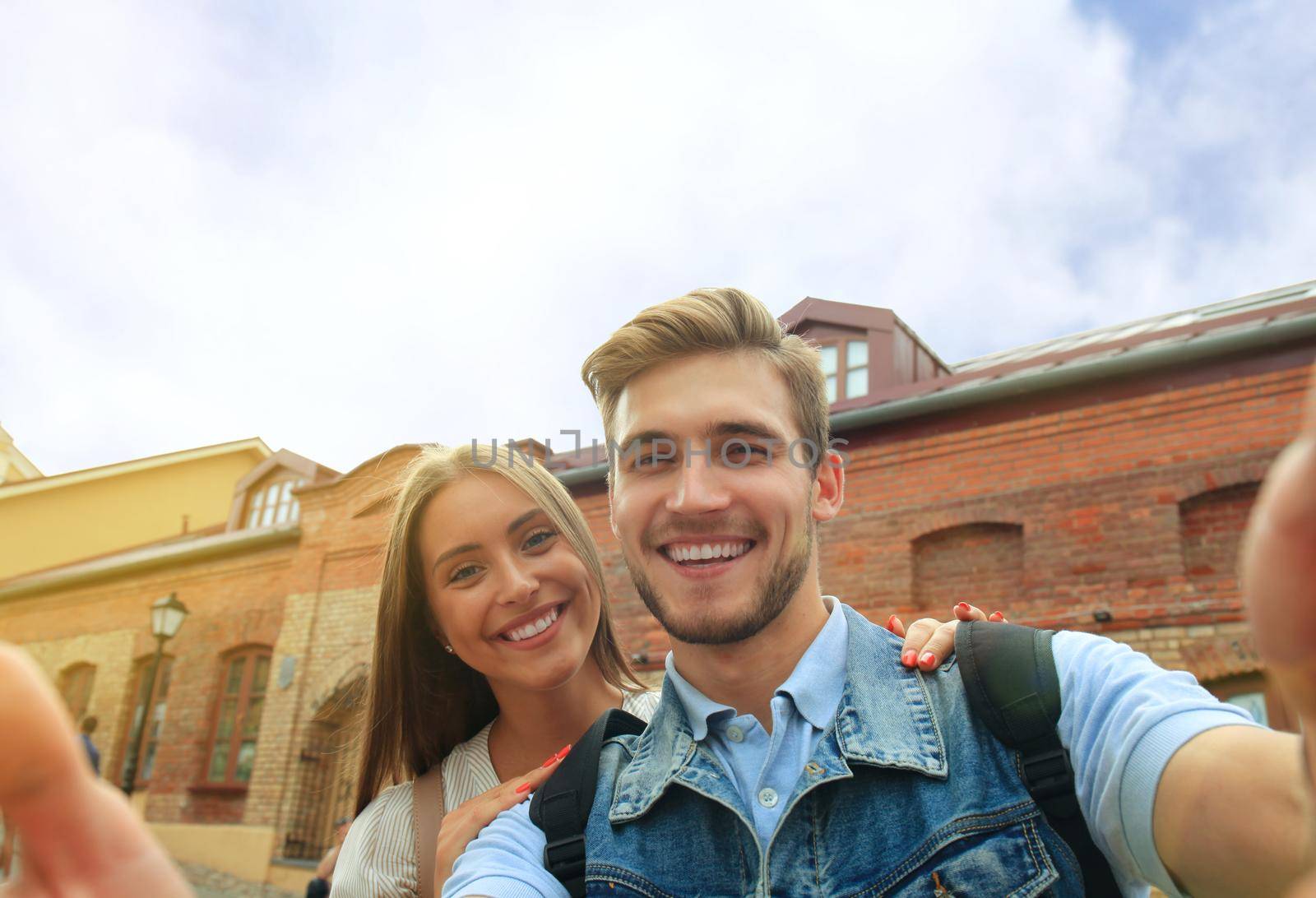 Happy couple of tourists taking selfie in old city. by tsyhun