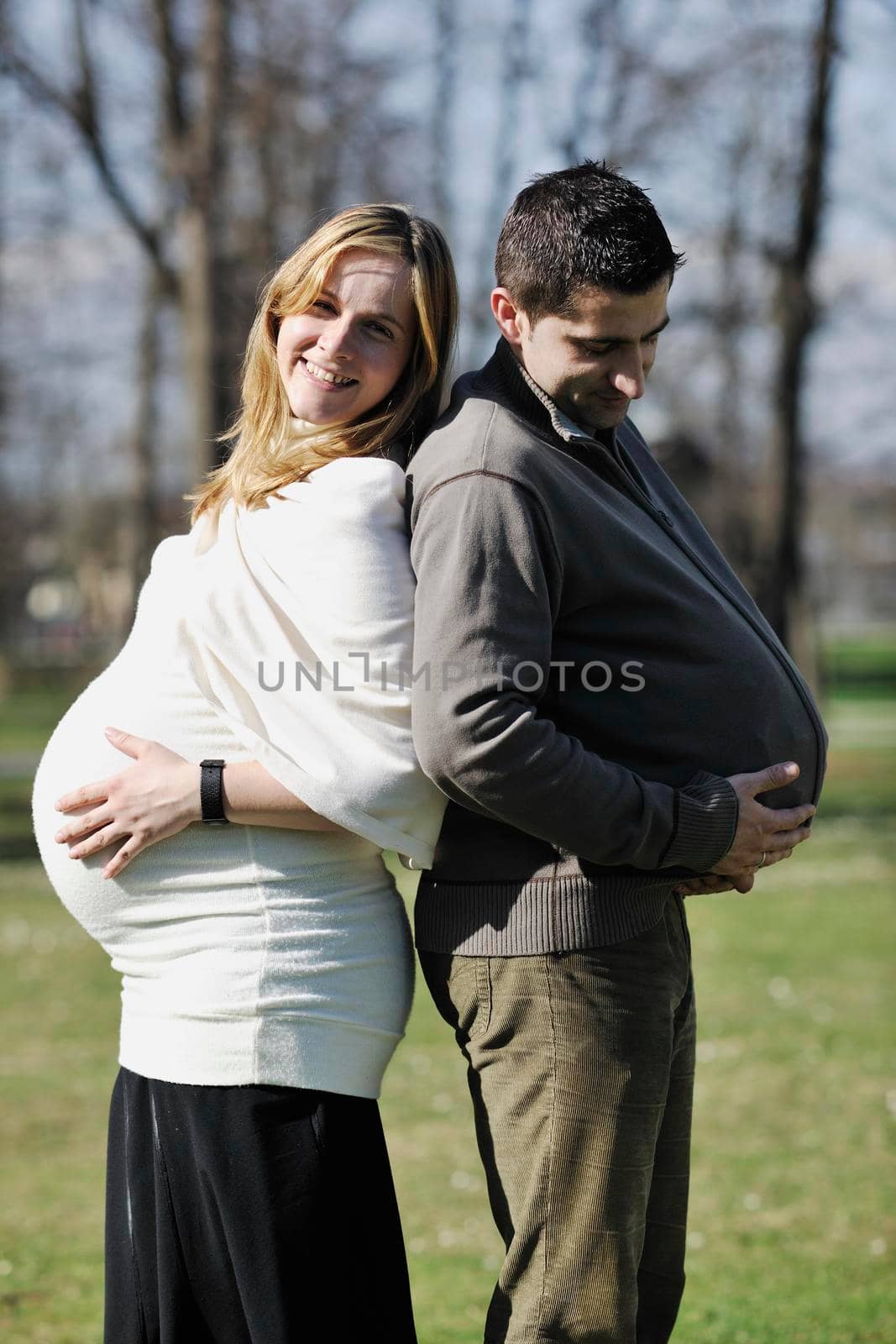 happy young married family couple outdoor in nature have fun and waiting baby and representing young family growth and pregnancy concept