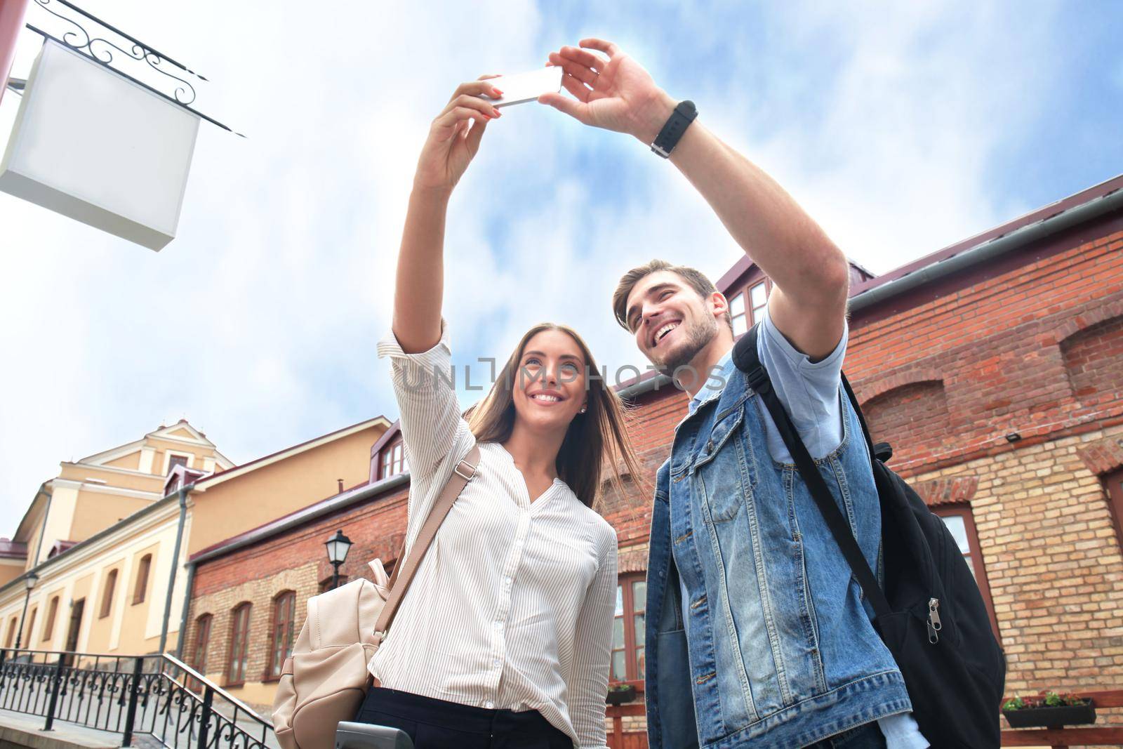 Happy couple of tourists taking selfie in old city. by tsyhun