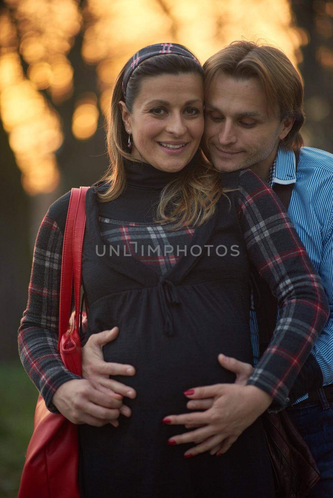 young pregnant couple have fun and relax by dotshock