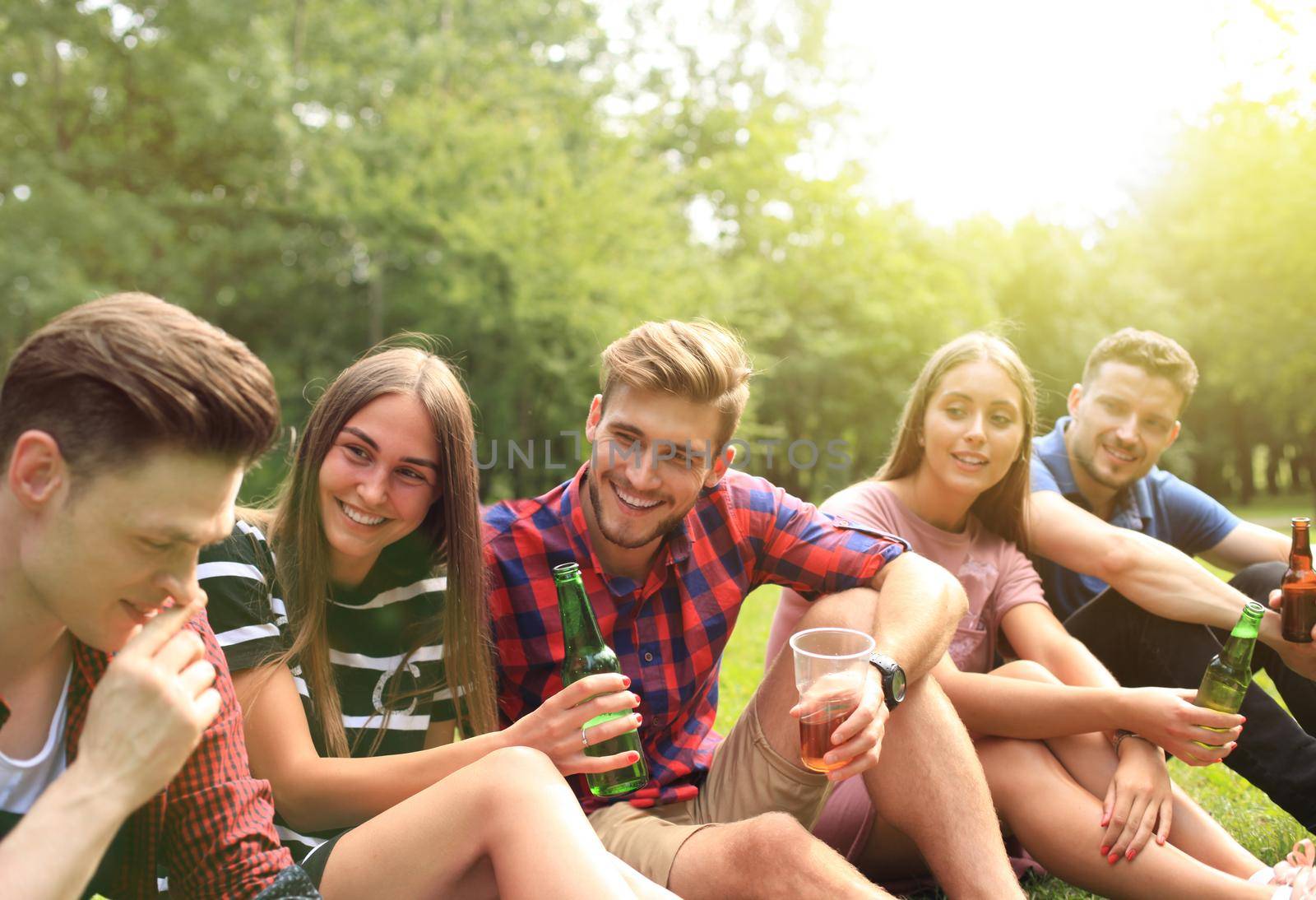 happy young friends enjoying picnic and eating. by tsyhun