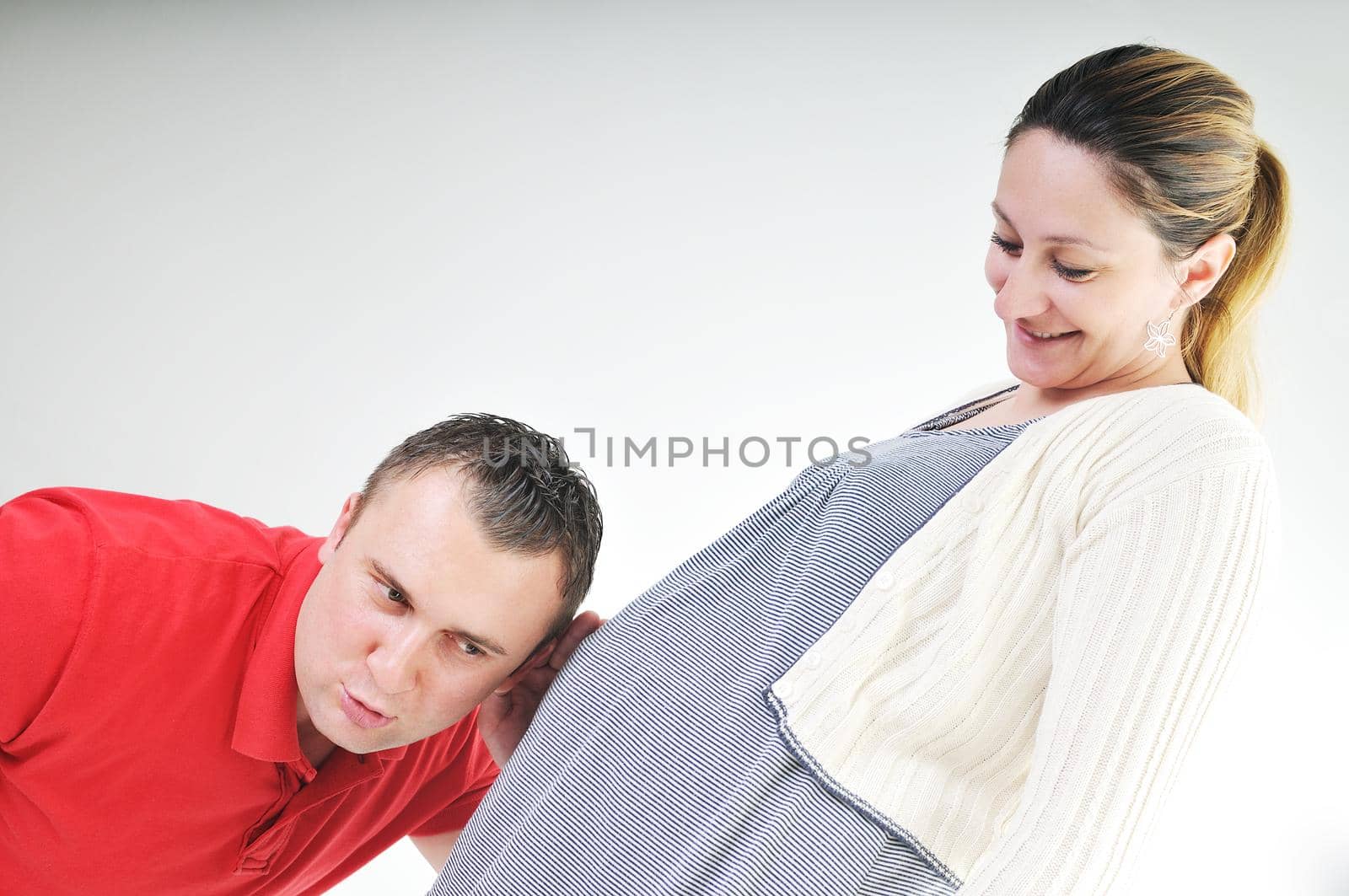 young family couple together in studio isolated on white. happy and waiting for baby