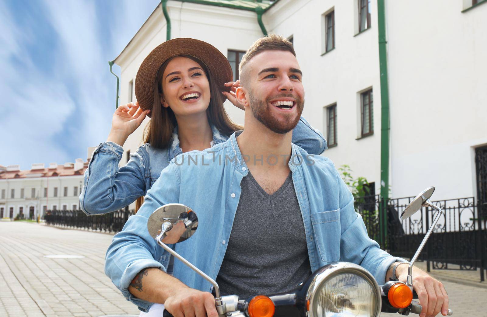 happy young couple riding scooter in town. Handsome guy and young woman travel. Adventure and vacations concept.