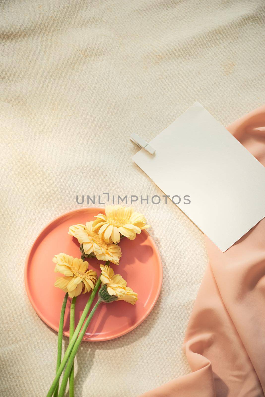Flowers on the plate with fabric and paper on yellow background  by makidotvn