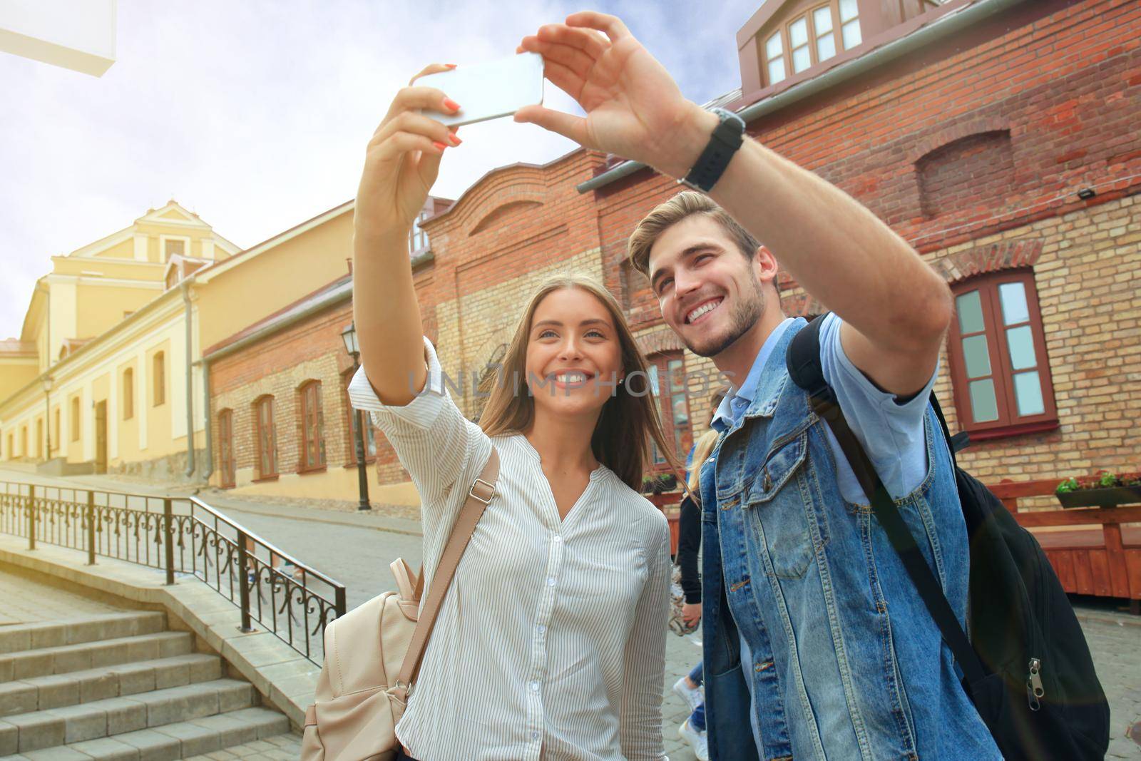 Happy couple of tourists taking selfie in old city. by tsyhun