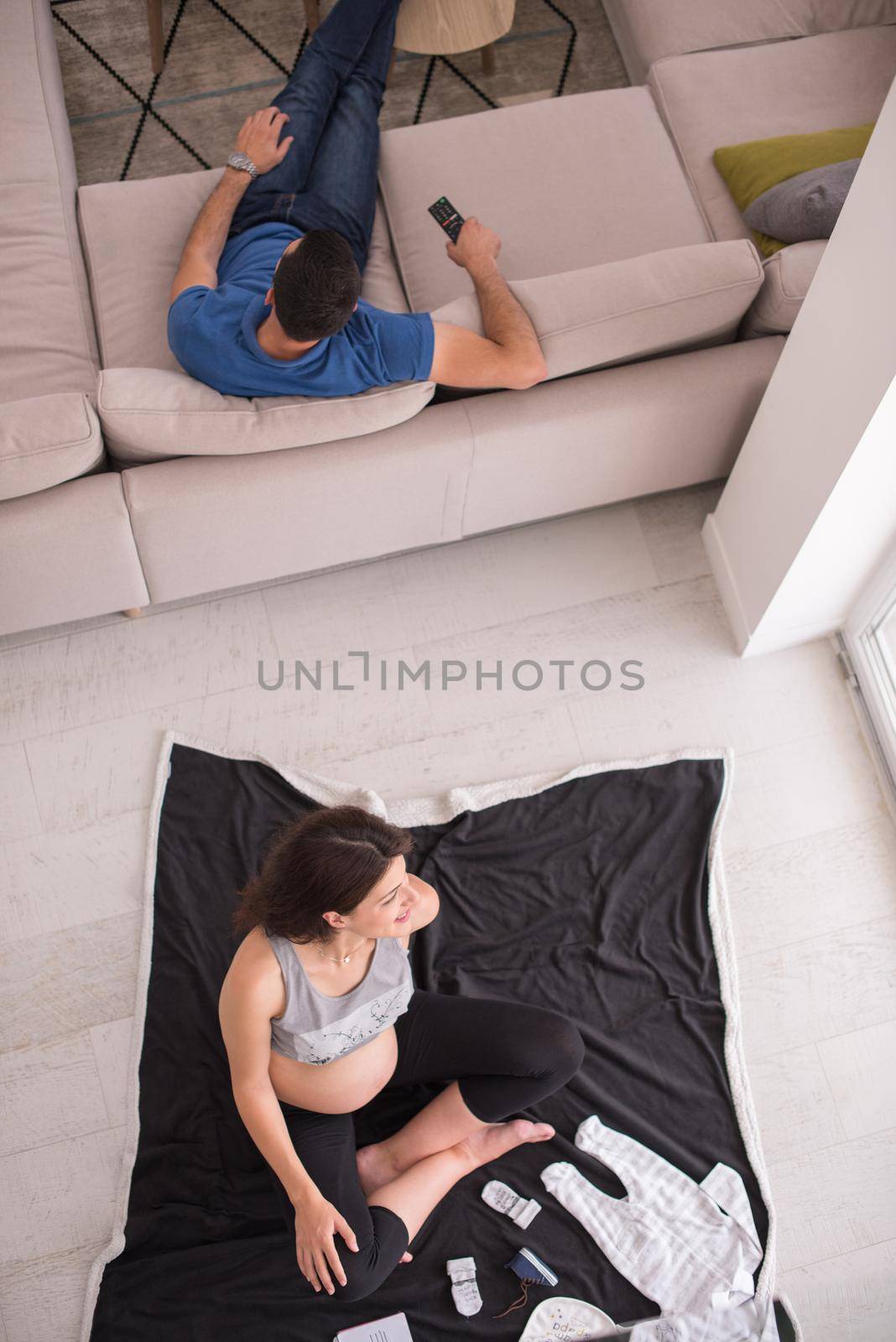 top view of pregnant woman checking list of baby clothes by dotshock