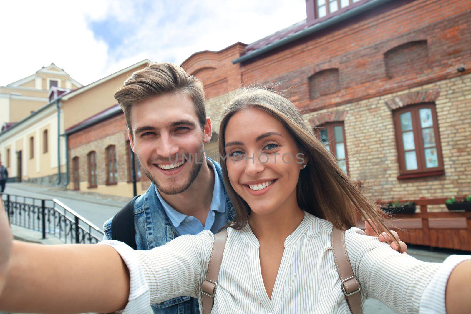 Happy couple of tourists taking selfie in old city. by tsyhun