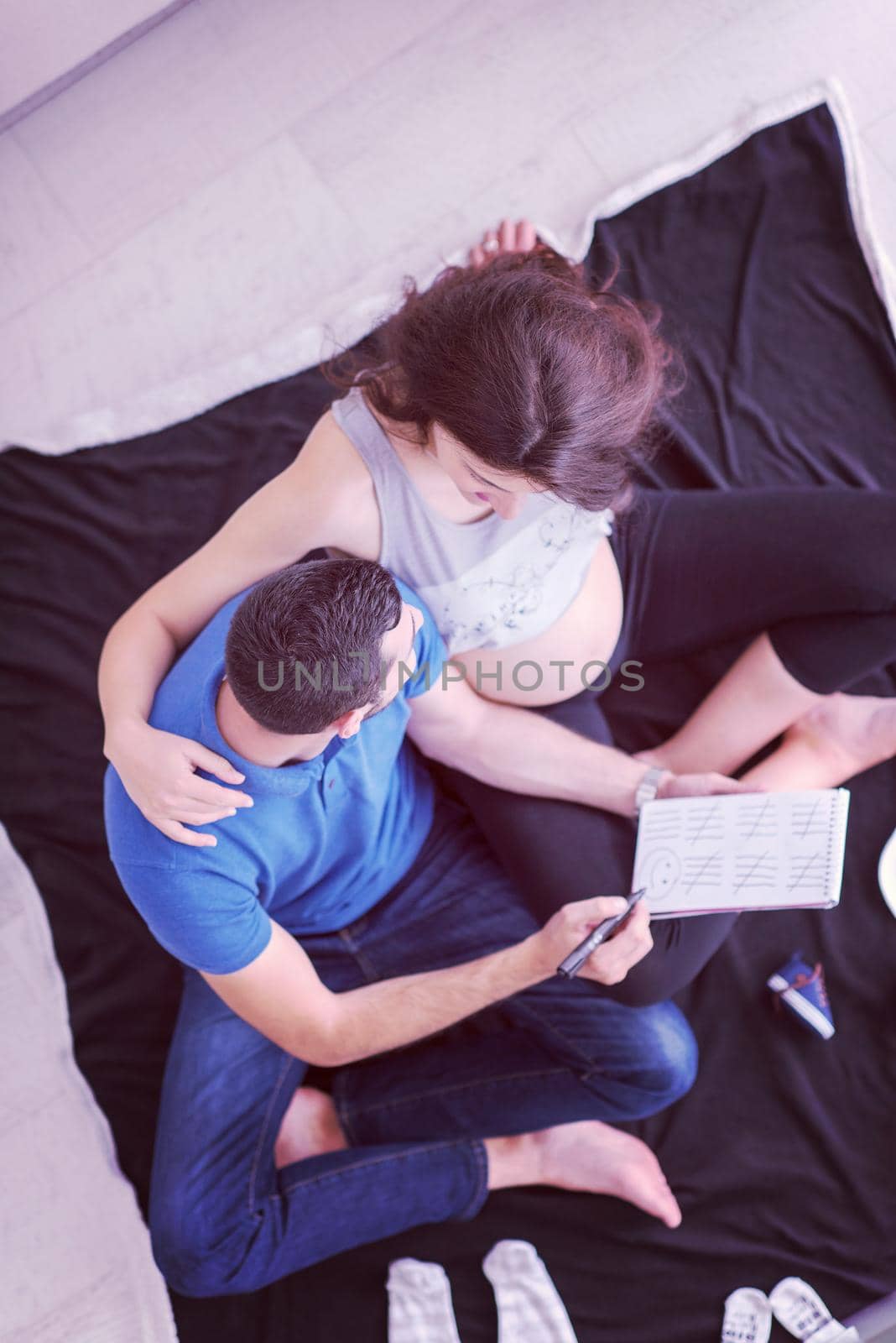 top view of couple checking a list of things for their unborn baby by dotshock