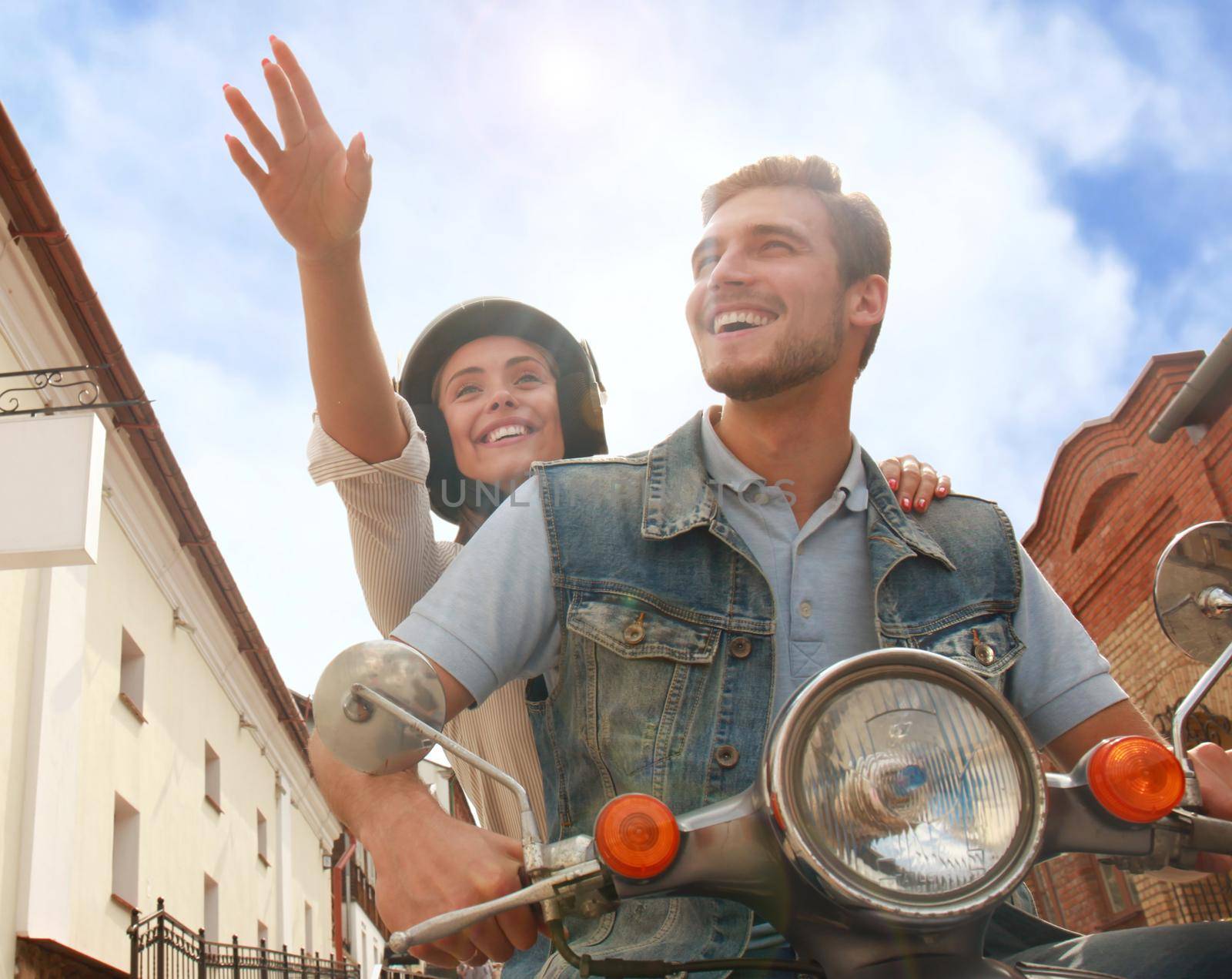 happy young couple riding scooter in town. Handsome guy and young woman travel. Adventure and vacations concept.