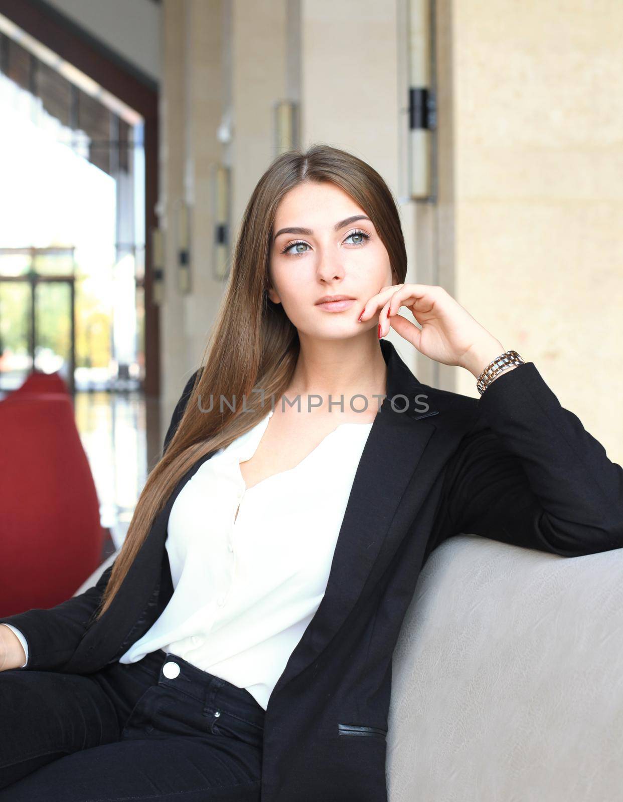 businesswoman sitting sofa using smartphone in coffee shop.