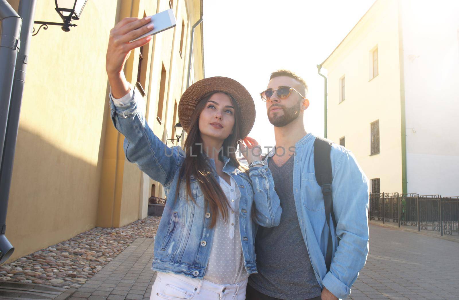 Happy couple of tourists taking selfie in old city. by tsyhun