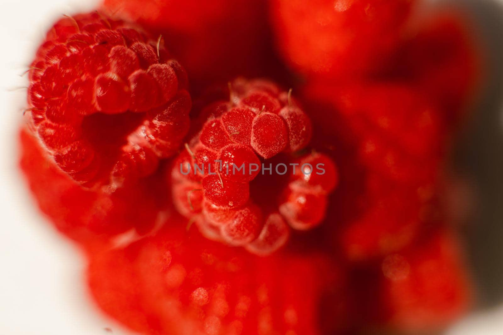 Beautiful raspberries in triangle shape lies isolated on a white background. Cut out, close up. Background and picture for postcard by StudioLucky