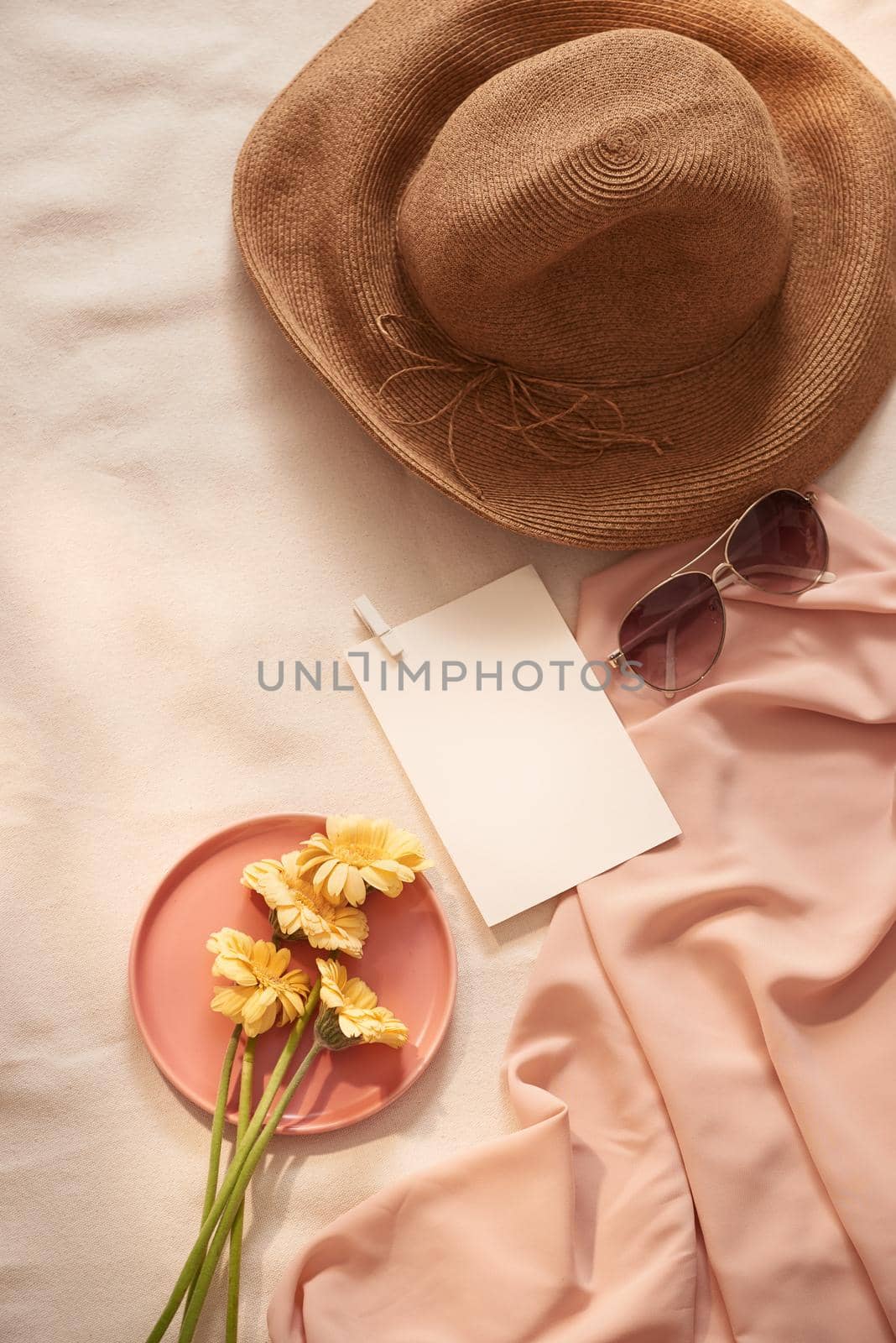 Flowers on the plate with hat, galsses and card on the light background by makidotvn