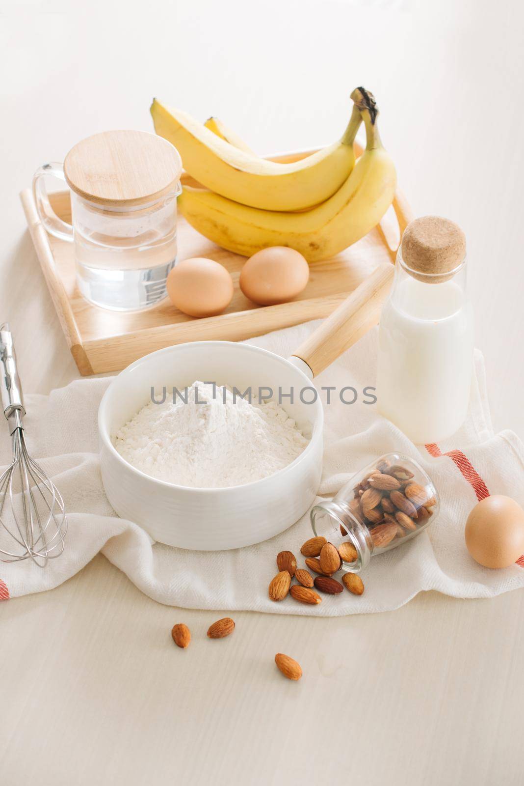 ingredients and tools to make banana cake on white background by makidotvn
