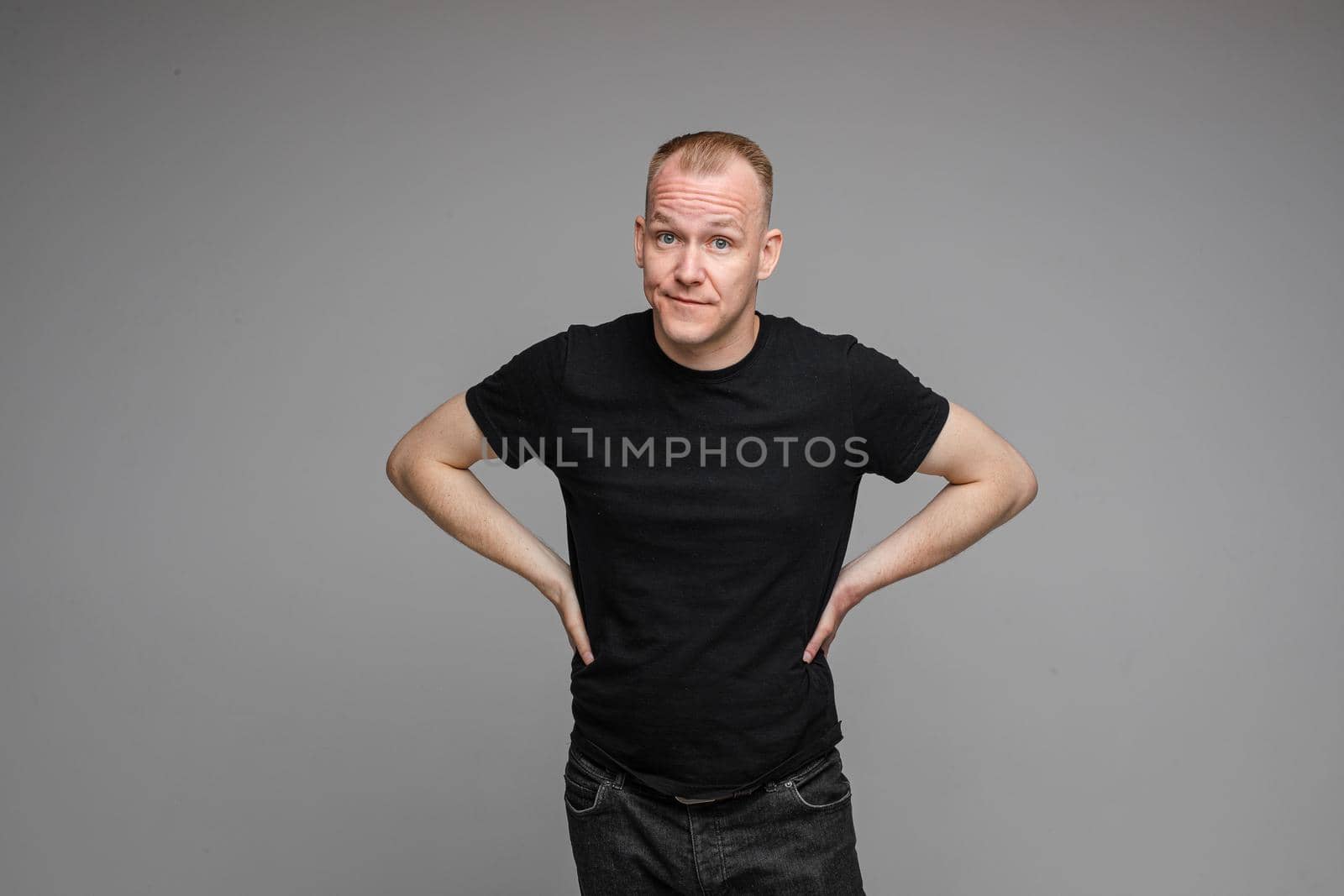 picture of caucasian male wearing a t-shirt and jeans isolated over the grey background