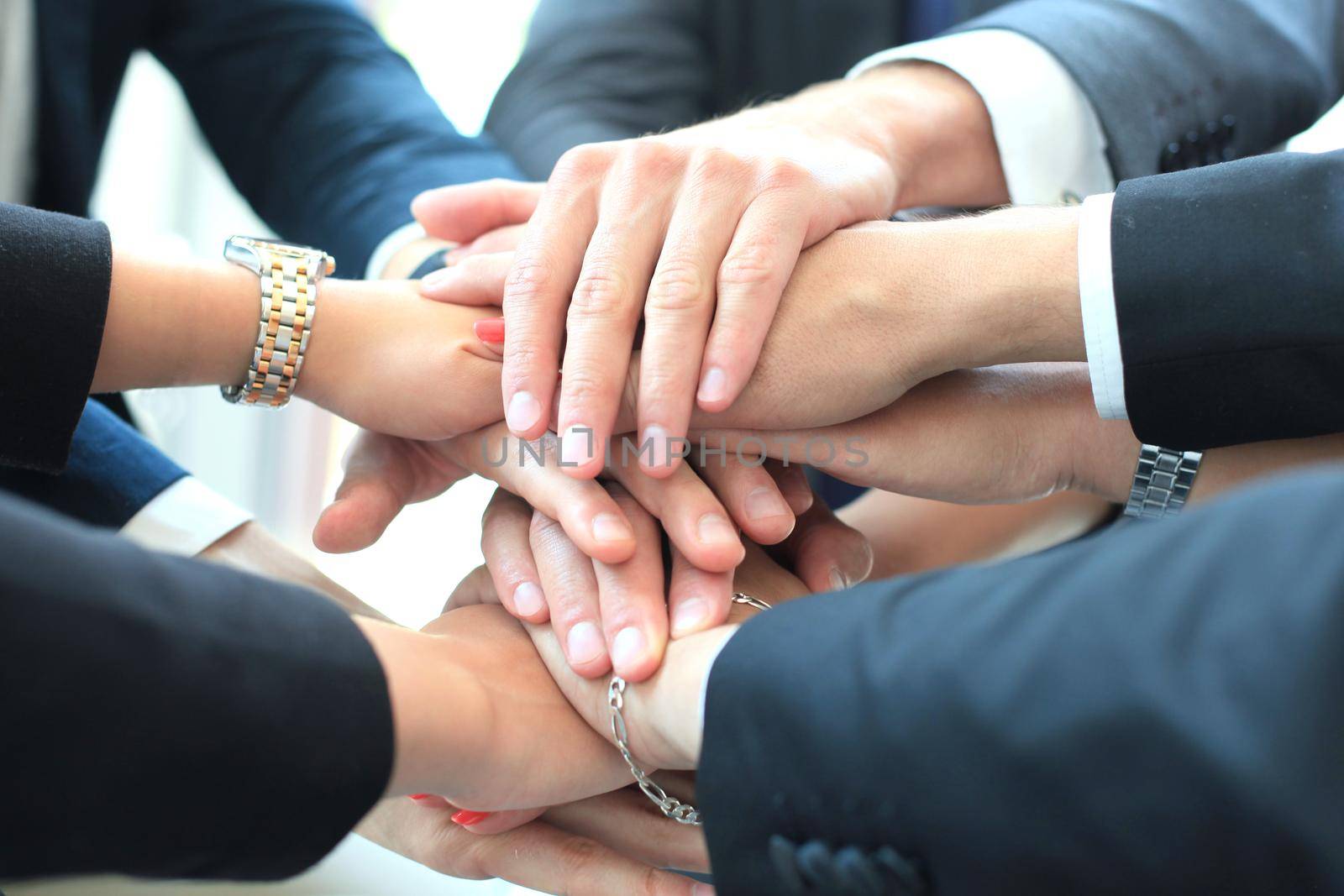 Businessman team in suit touching hands together. Selective focus.