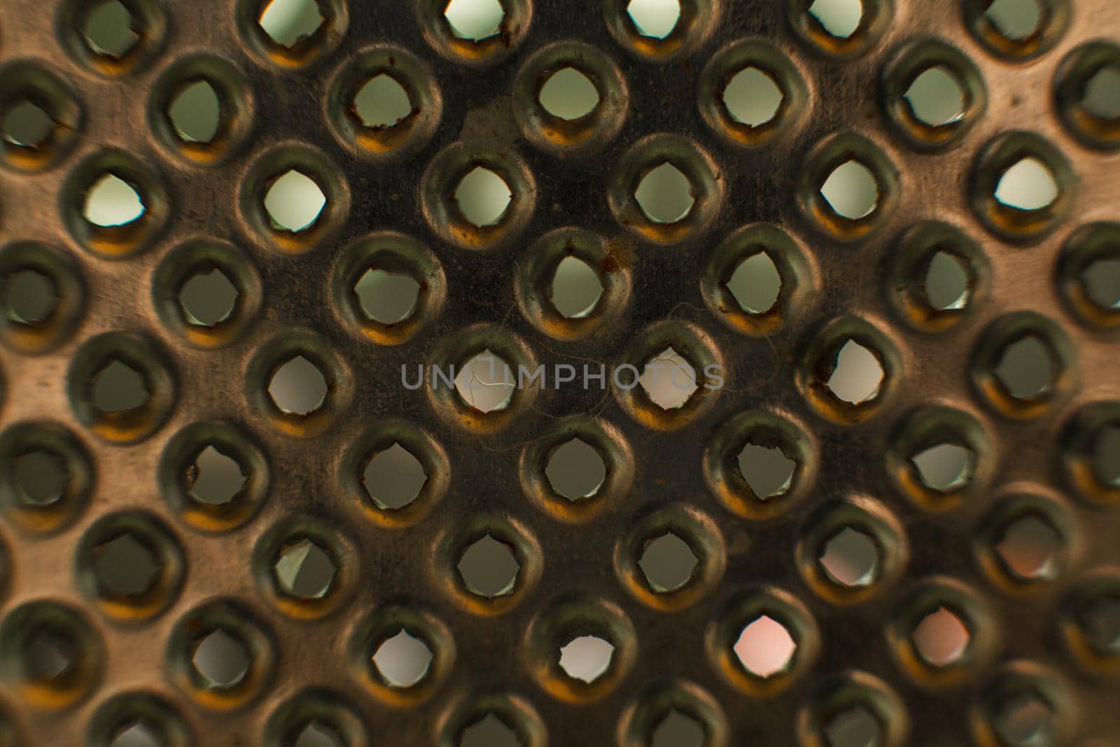 Ordinary metal kitchen grater with round holes on it, picture background by StudioLucky