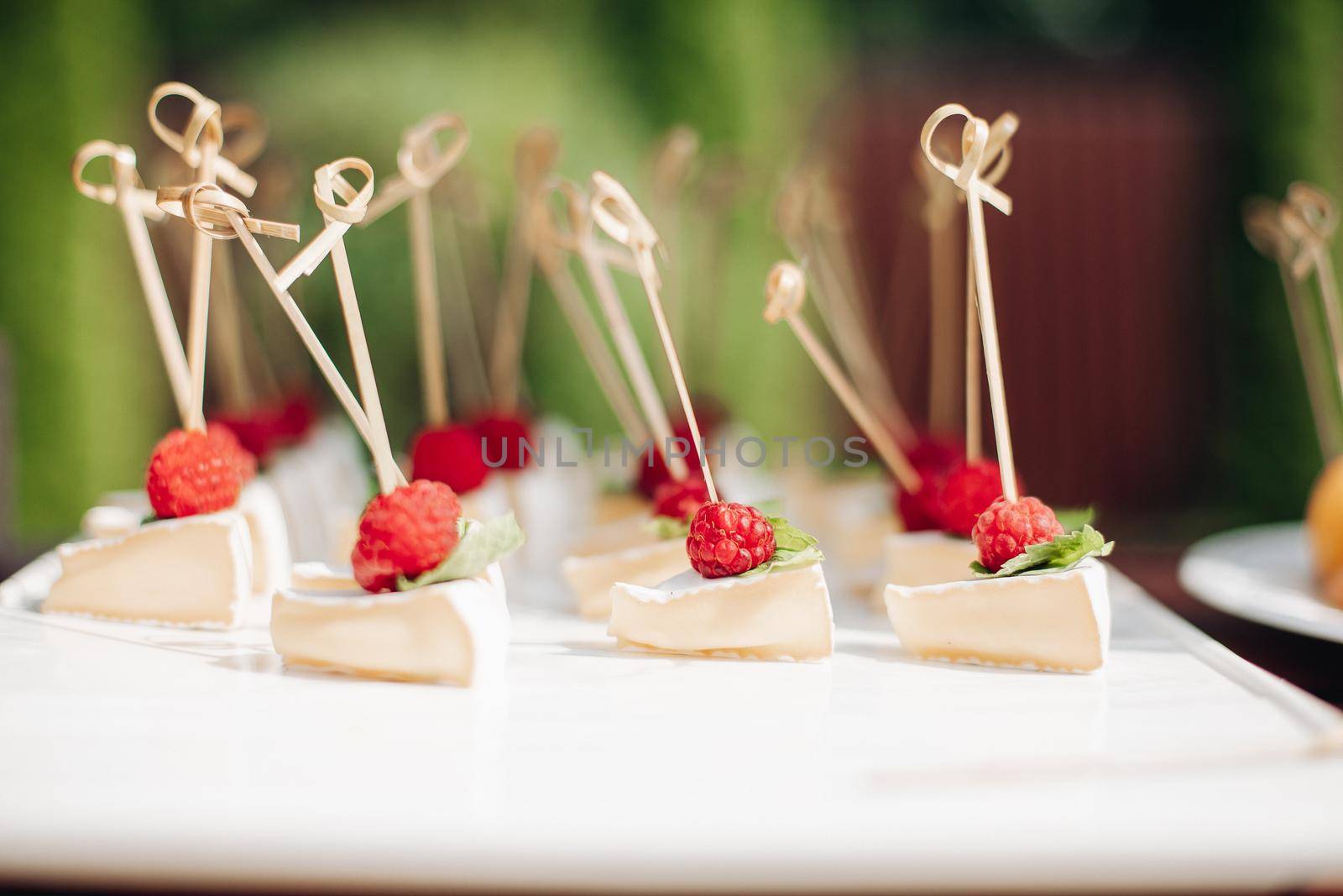 yummy homemade triangle pieces of cheescake with raspberries on the table