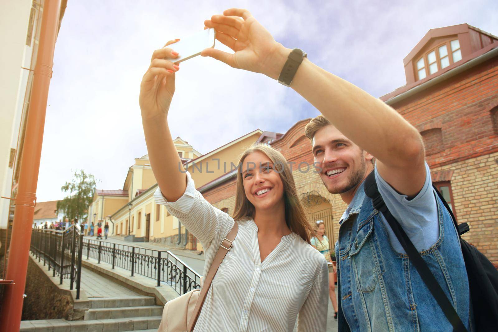 Happy couple of tourists taking selfie in old city.