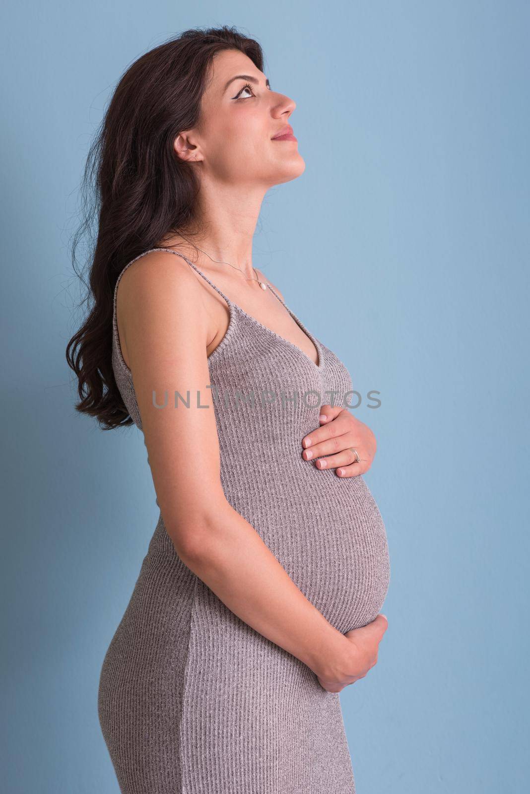 Portrait of pregnant woman over blue background by dotshock