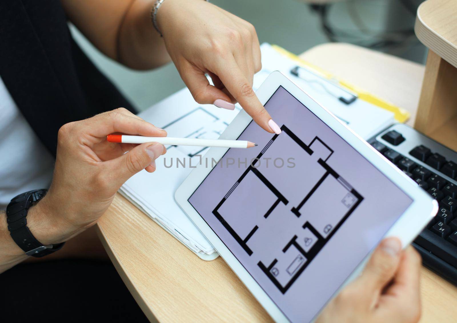 Real-estate agent showing house plans on electronic tablet