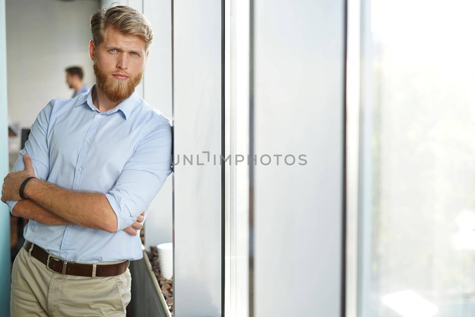 Portrait of a happy young casual businessman at office, smiling.