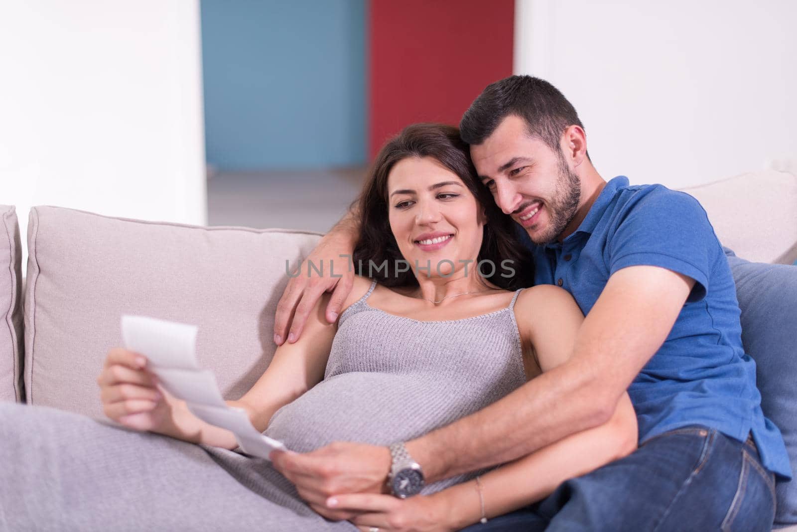 pregnant couple looking baby's ultrasound by dotshock